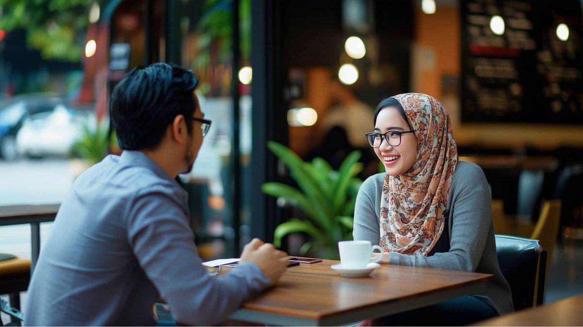 Two people talking over coffee at a table.
